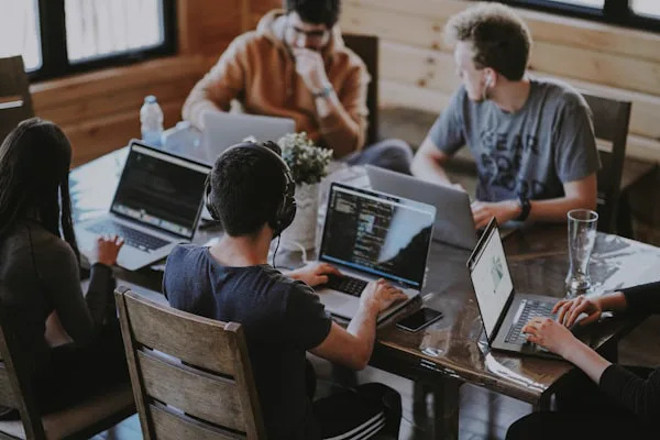 Undergraduate students working together on laptops